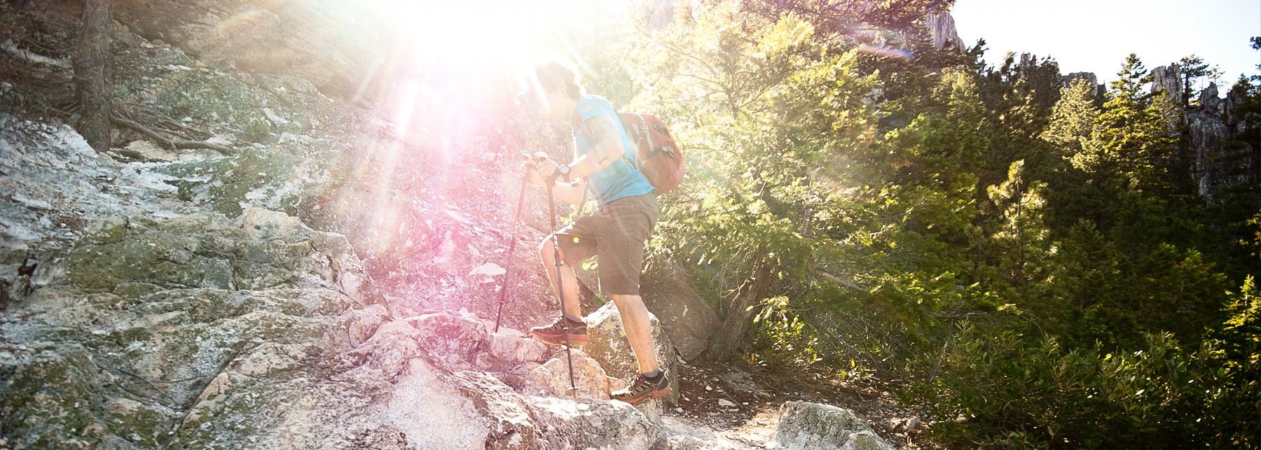 Man climbing a rocky trail with Leki poles